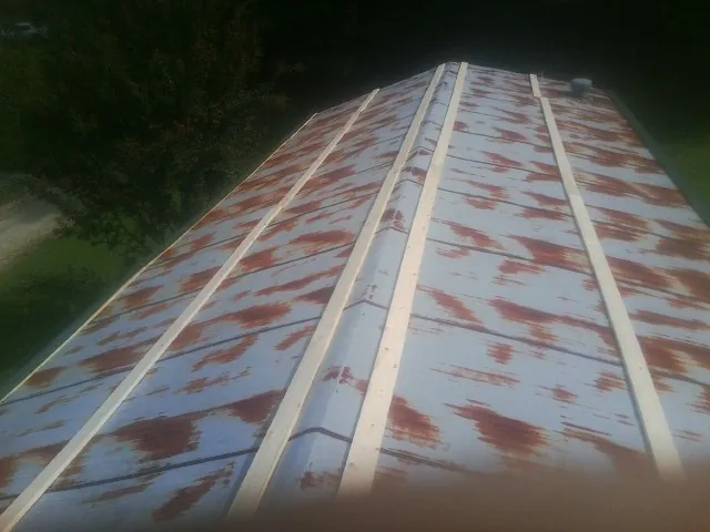 Rusted metal roof panels with new wood purlins before replacement — Storm Damage Roof Repair in Little Elm by Roofing Brothers