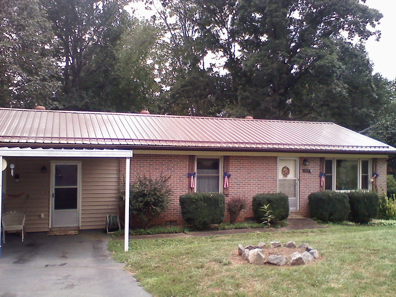 Bronze metal roof and carport on a brick ranch home — Roof Repair work by our crew in Little Elm